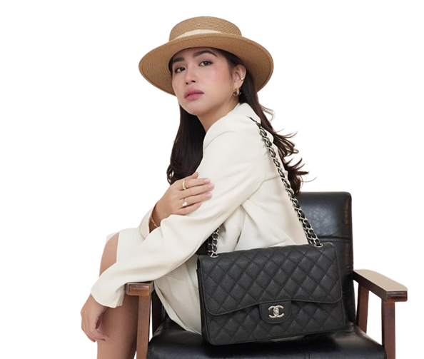 Keiselyn Benitez, the founder of KCLUXURYBAGS, posing with a curated collection of authentic luxury handbags.