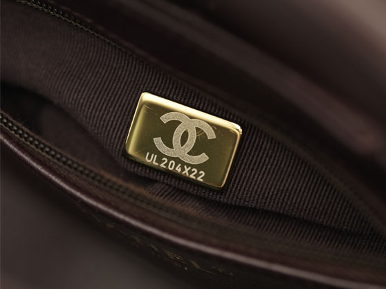 Engraved Chanel microchip plaque with CC logo inside a brown lining